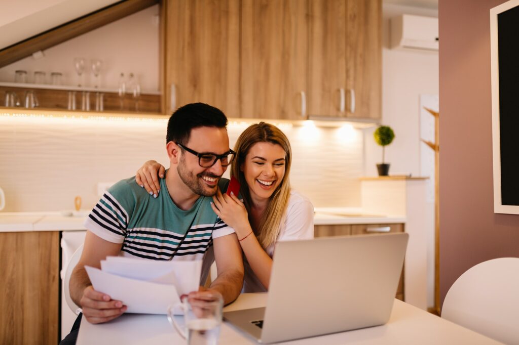 Young couple calculating their domestic budget together in living room.